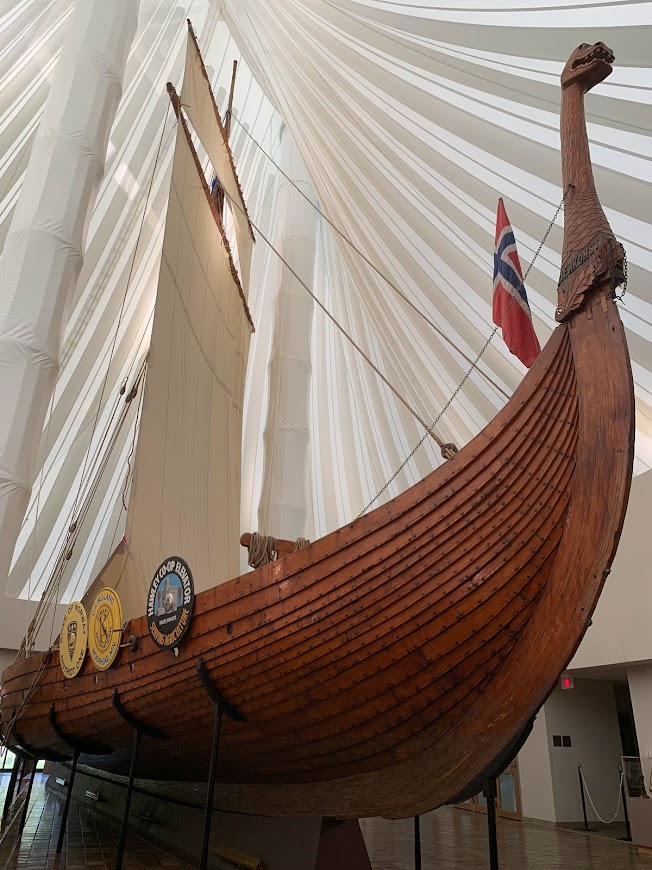 A large contemporary viking ship inside a museum seen from below.